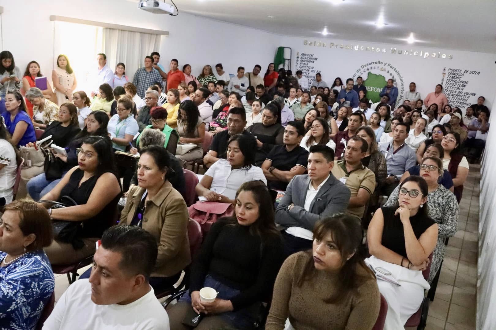 Puede ser una imagen de 3 personas, personas estudiando, personas sonriendo y multitud